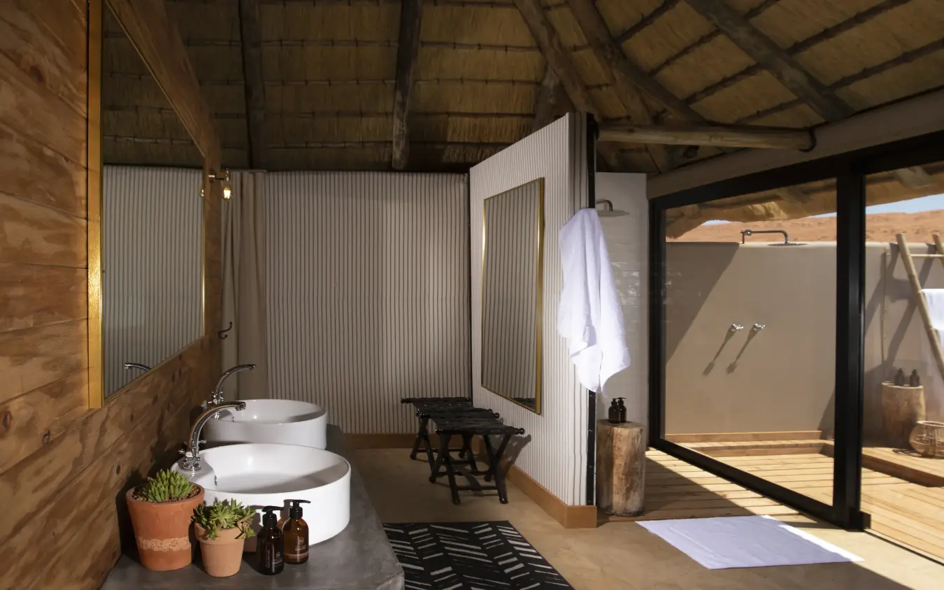Luxury safari bathroom with twin circular basins and open-air shower pavilion, Kwessi Dunes, NamibRand Private Reserve, Namibia