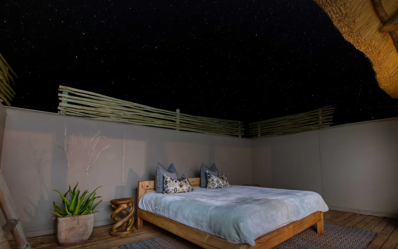 Bedroom interior with open sides overlooking starlit night sky, Kwessi Dunes, NamibRand Private Reserve, Namibia