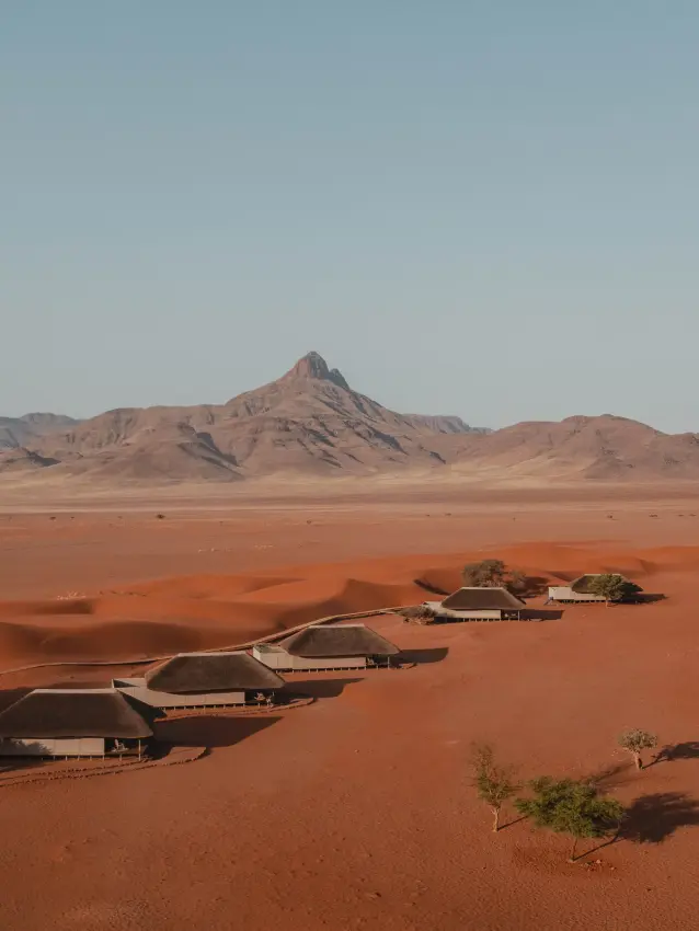 Luxury desert lodge nestled among dunes with mountain backdrop, Kwessi Dunes, NamibRand Private Reserve, Namibia