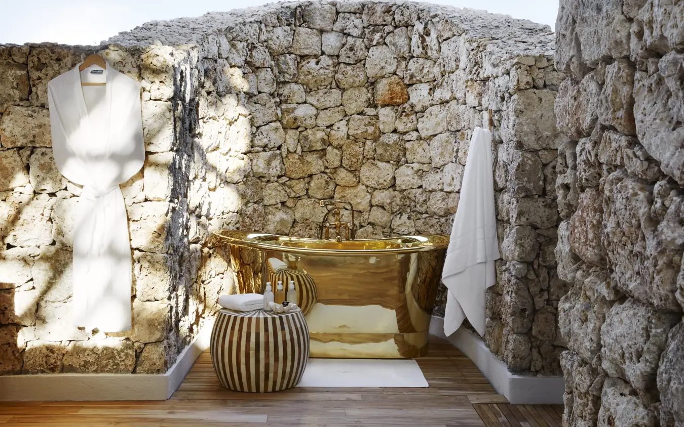 Luxe outdoor bathroom with brass tub nestled against ancient stone walls, Laba Fanjove, Zanzibar & Pemba, Tanzania