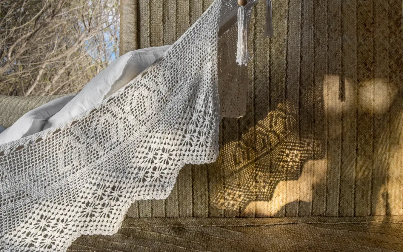 Delicate lace curtain drying on wooden deck railing with shadow patterns, Laba Fanjove, Zanzibar & Pemba, Tanzania