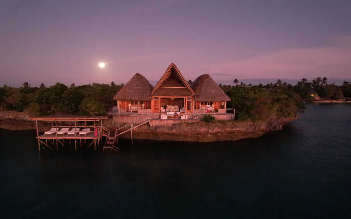 Overwater lodge with thatched bungalows at dusk with full moon, Laba Fanjove, Zanzibar & Pemba, Tanzania