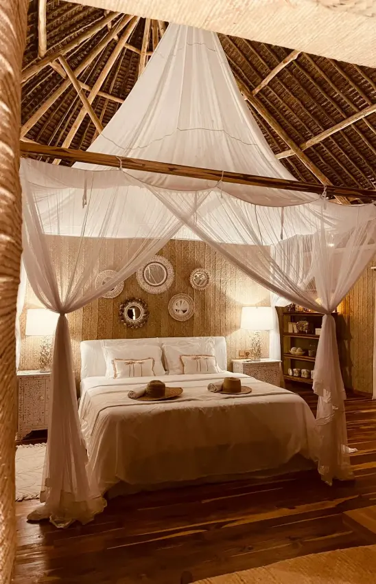 Canopy bed with sheer drapes in thatched roof bedroom, Laba Fanjove, Zanzibar & Pemba, Tanzania