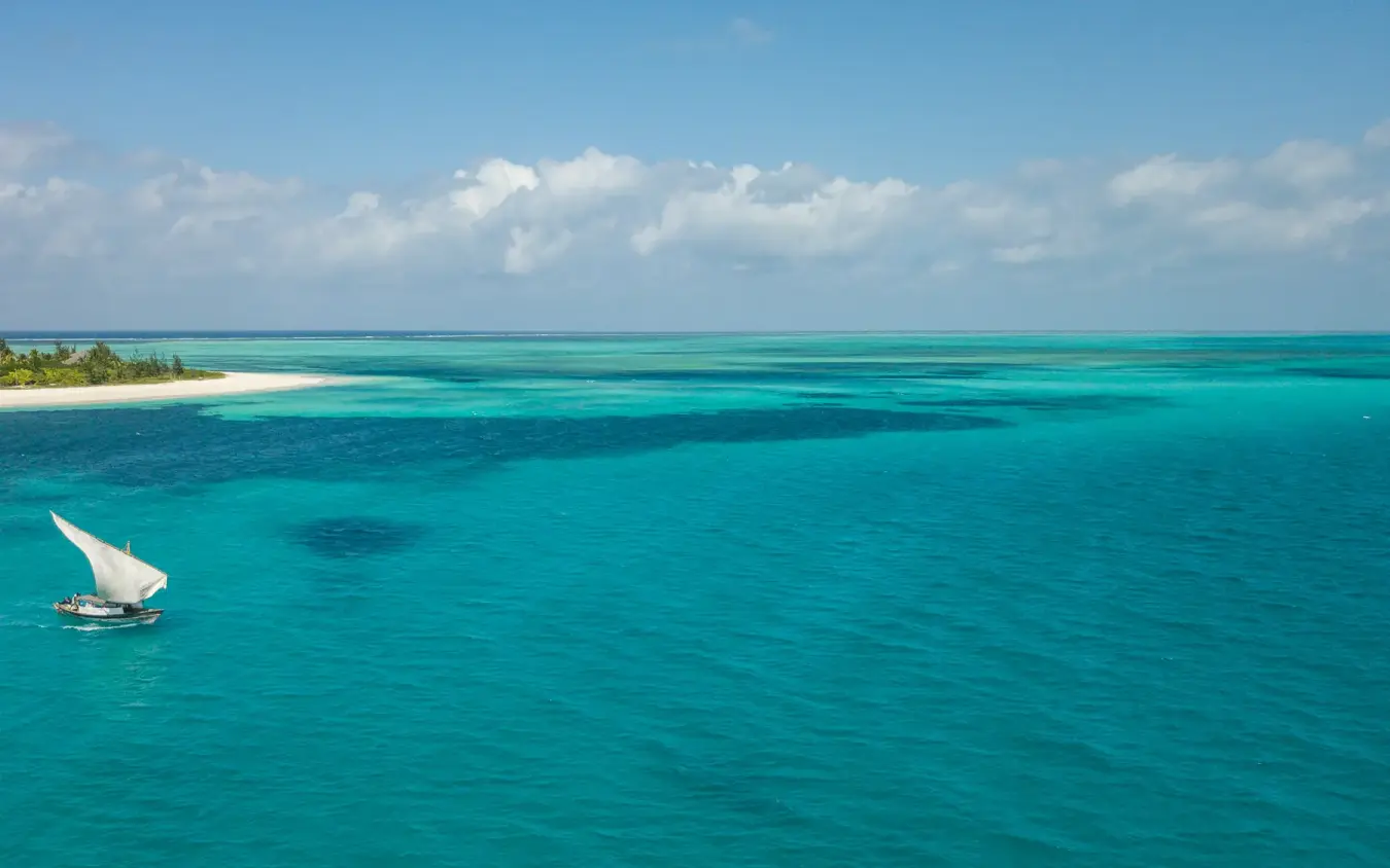 Traditional sailing dhow anchored in turquoise lagoon near sandy island, Laba Fanjove, Zanzibar & Pemba, Tanzania