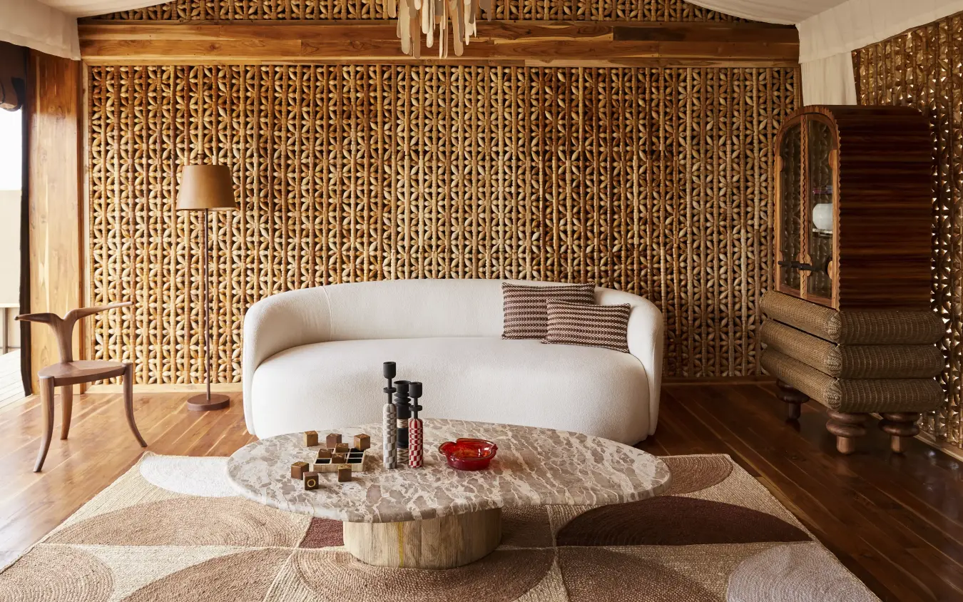 Luxury bedroom interior with curved bed and carved wooden wall panels, Laba Grumeti Art Lodge, Serengeti National Park, Tanzania