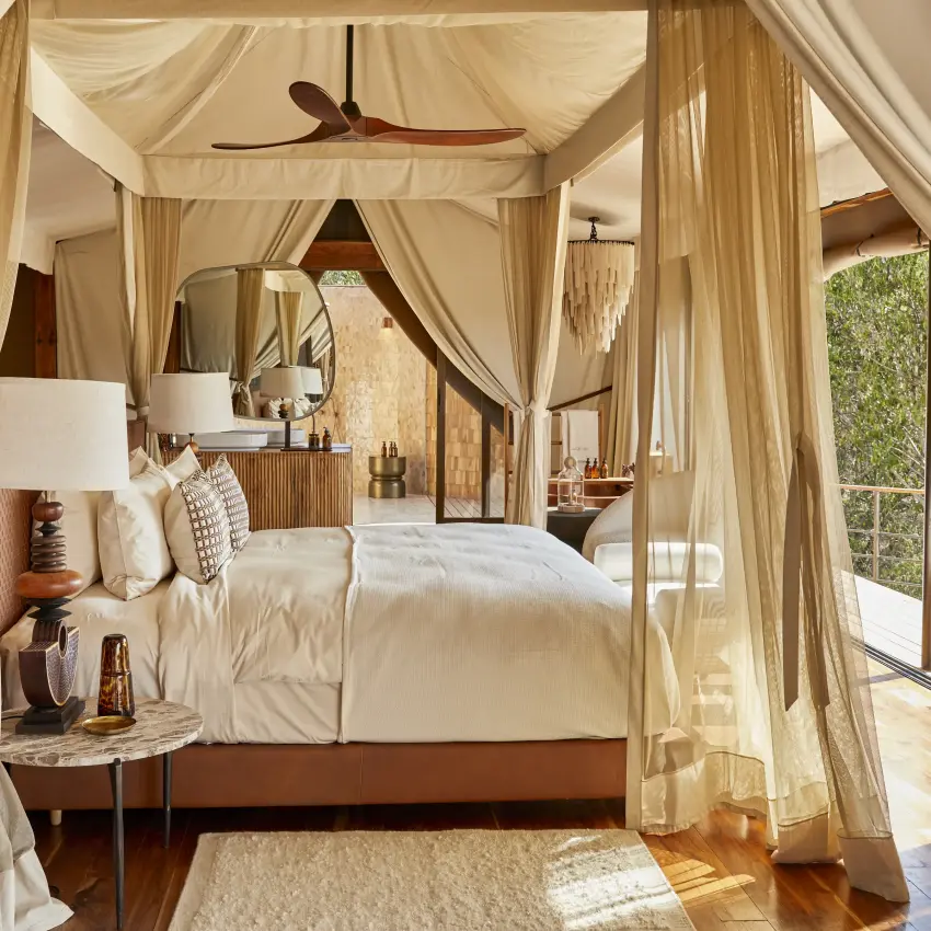 Luxury safari bedroom with four-poster canopy bed and outdoor deck views, Laba Grumeti Art Lodge, Serengeti National Park, Tanzania