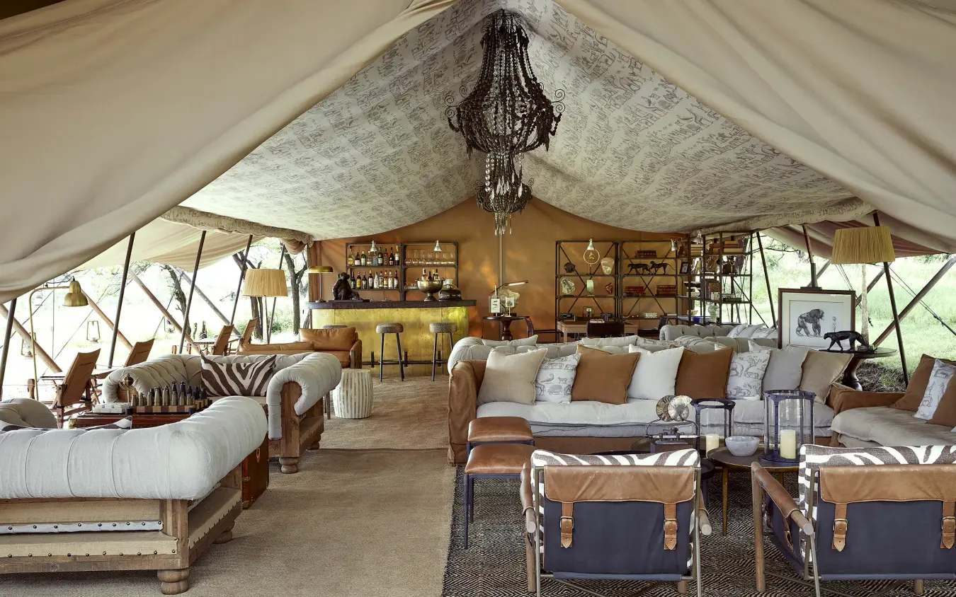 Luxury safari tent interior with lounge seating and bar area, Laba Migration Camp, Serengeti National Park, Tanzania
