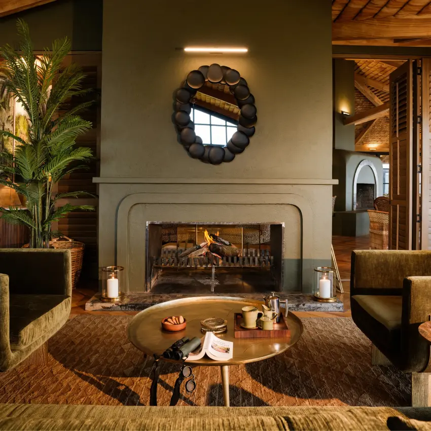 Modern lounge with fireplace, seated guests, and decorative plants indoors, Laba Ngorongoro Lodge, Ngorongoro Crater, Tanzania