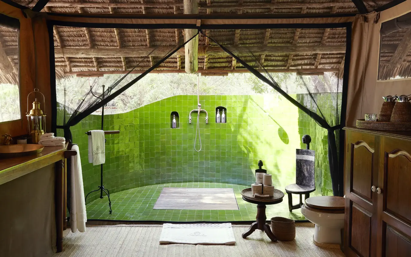 Luxury open-air bathroom with green tile shower overlooking natural landscape, Laba Siwandu, Nyerere National Park, Tanzania