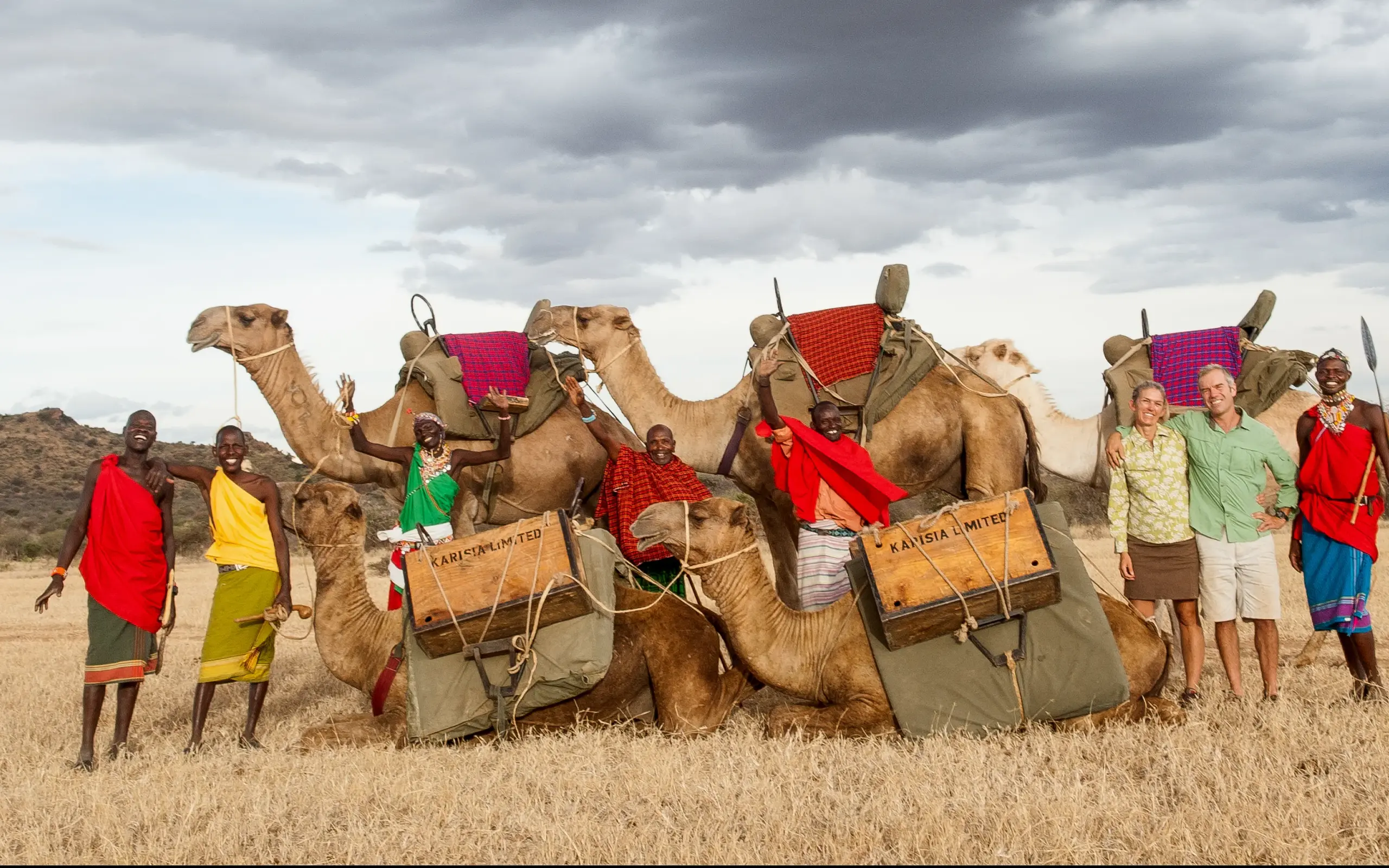 Safari guides and guests posing with decorated camels, Karisia Walking Safaris, Laikipia Highlands, Kenya
