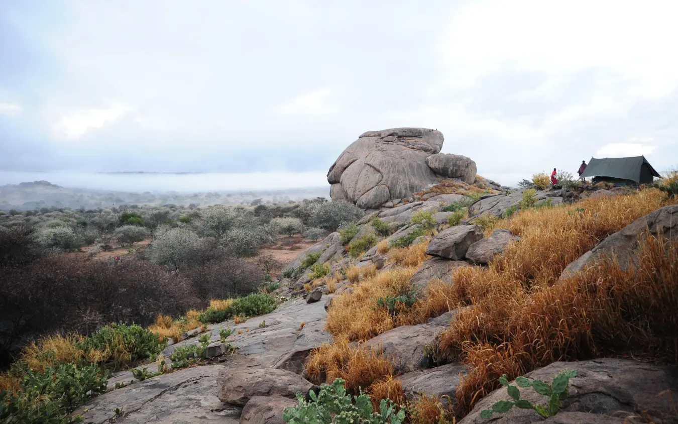 Rocky hilltop with distant savanna and small shelter building, Karisia Walking Safaris, Laikipia Highlands, Kenya