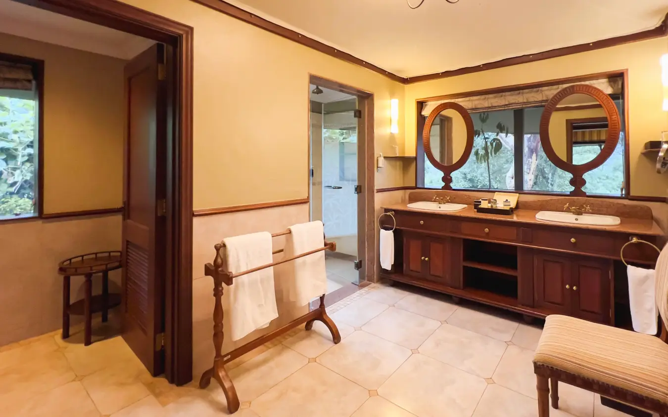Luxury bathroom with dual vanity and wooden furnishings overlooking gardens, Lake Elmenteita Serena Camp, Rift Valley Lakes, Kenya