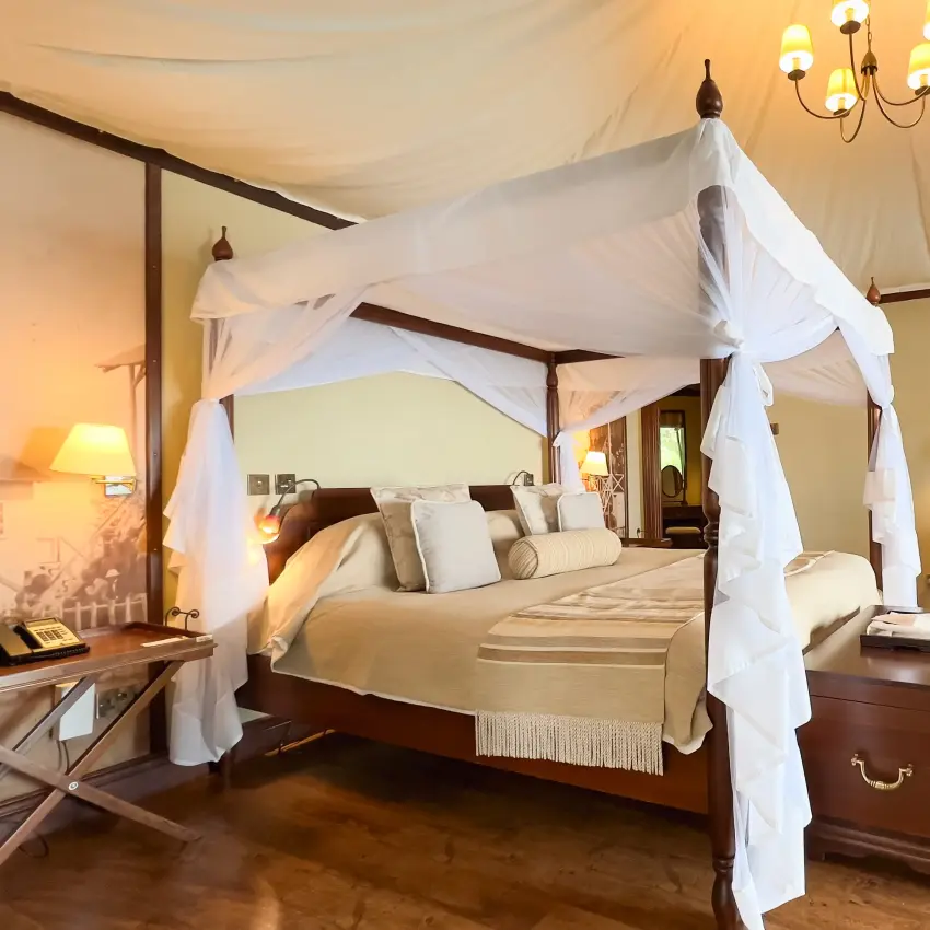 Four-poster bed with white drapes in luxury safari lodge bedroom, Lake Elmenteita Serena Camp, Rift Valley Lakes, Kenya