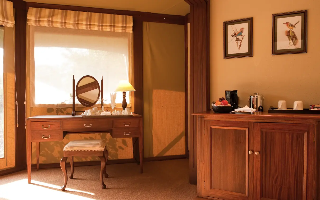 Luxury bedroom suite with wooden furniture and savanna-view window, Lake Elmenteita Serena Camp, Rift Valley Lakes, Kenya