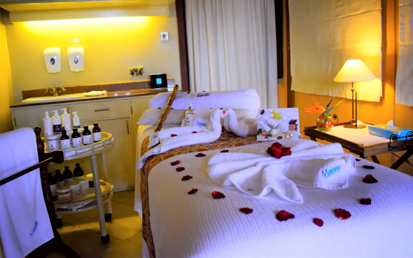 Spa bedroom with massage table and luxury amenities in warm lighting, Lake Elmenteita Serena Camp, Rift Valley Lakes, Kenya