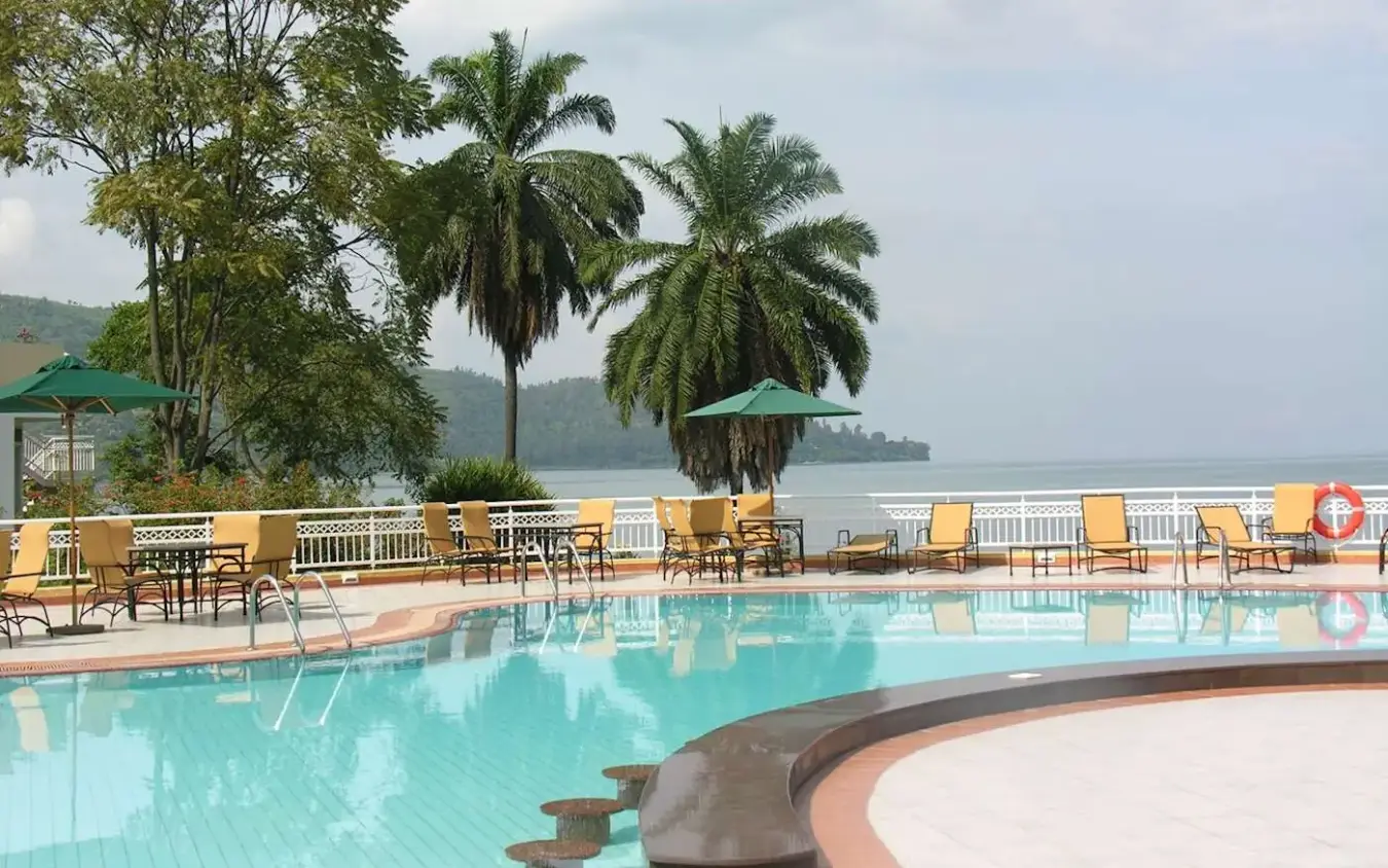 Lakeside swimming pool with lounge chairs and palm trees, Lake Kivu Serena Hotel, Lake Kivu, Rwanda