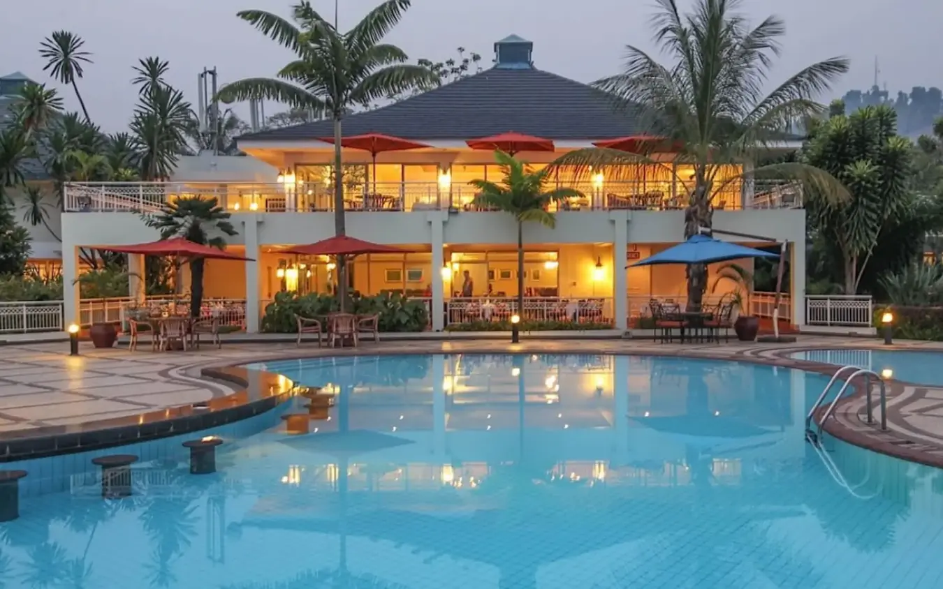 Illuminated lakeside lodge with curved swimming pool at dusk, Lake Kivu Serena Hotel, Lake Kivu, Rwanda