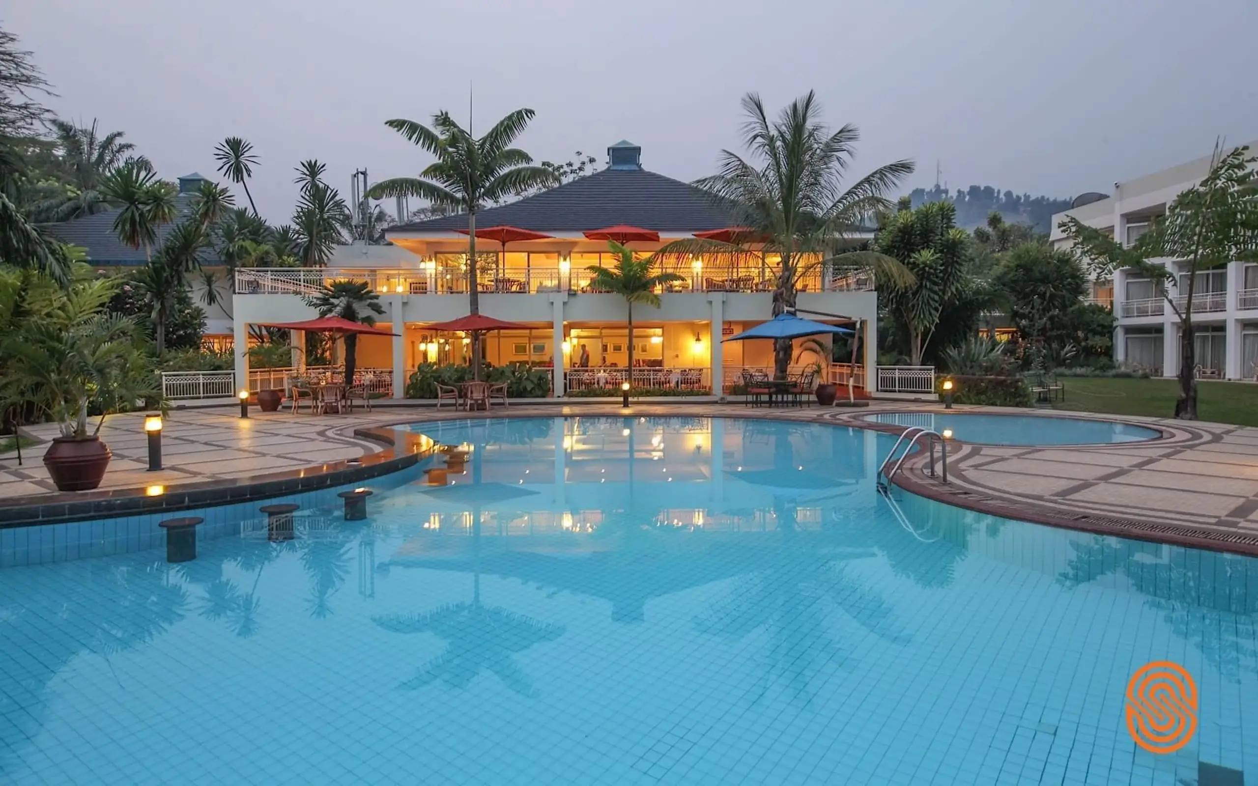 Illuminated lakeside lodge with large swimming pool at dusk, Lake Kivu Serena Hotel, Lake Kivu, Rwanda