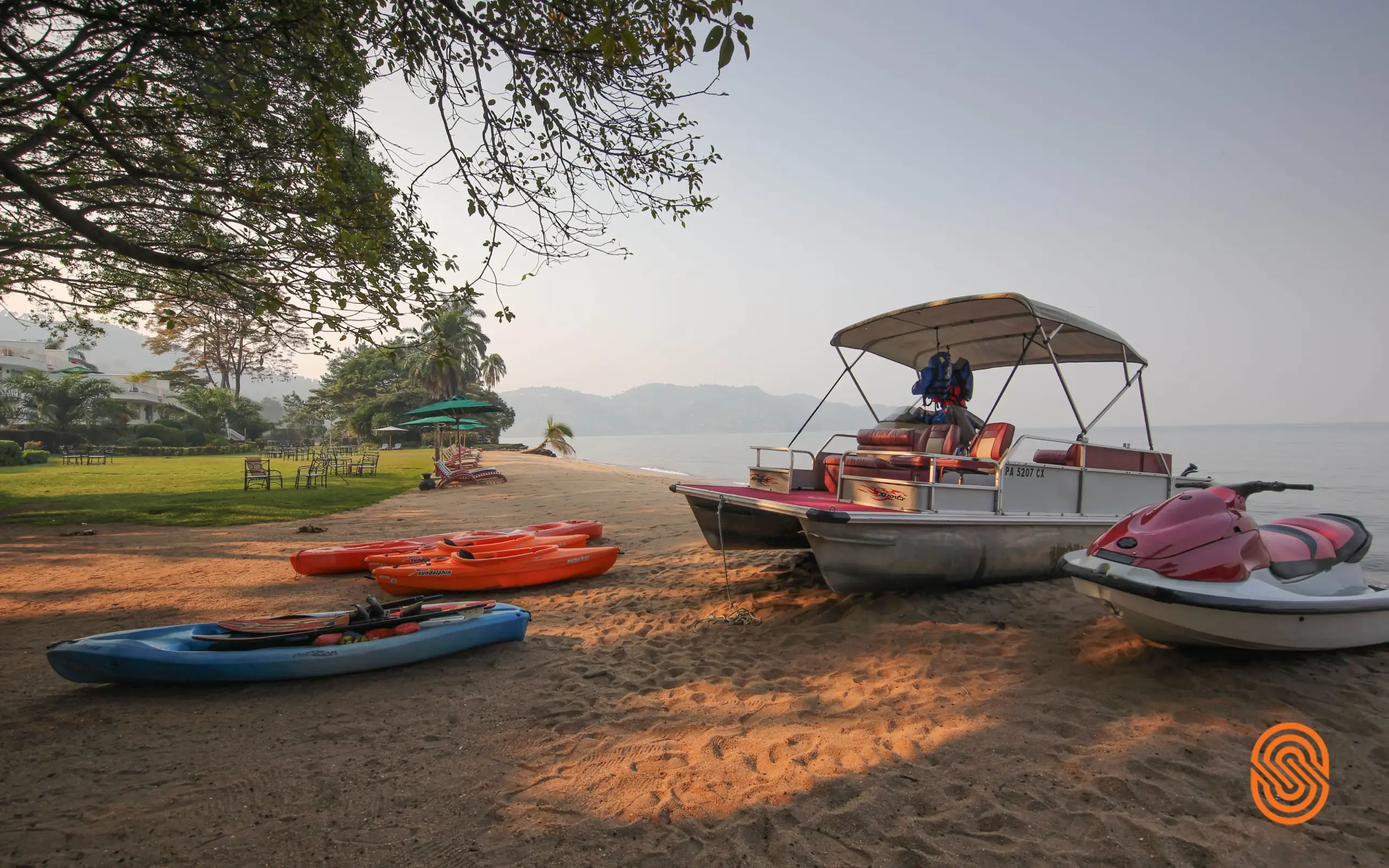 Beached kayaks and boats on sandy shore at dawn, Rwanda