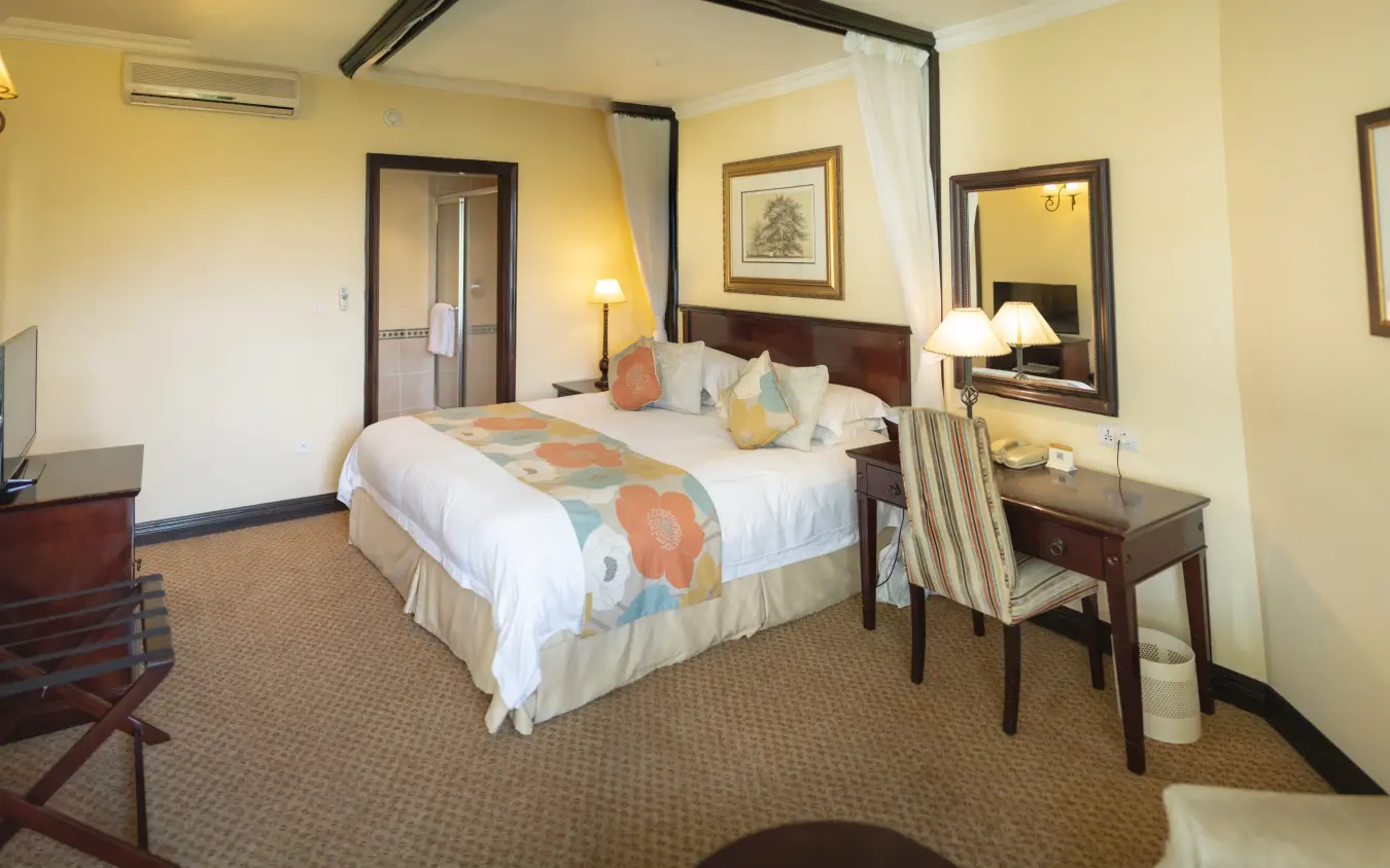 Luxury hotel bedroom with four-poster bed and ensuite bathroom, Lake Kivu Serena Hotel, Lake Kivu, Rwanda