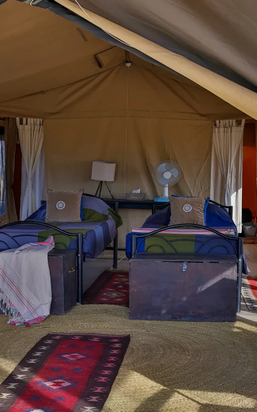 Safari tent bedroom interior with multiple beds and furnishings, Lake Natron Camp, Lake Natron, Tanzania