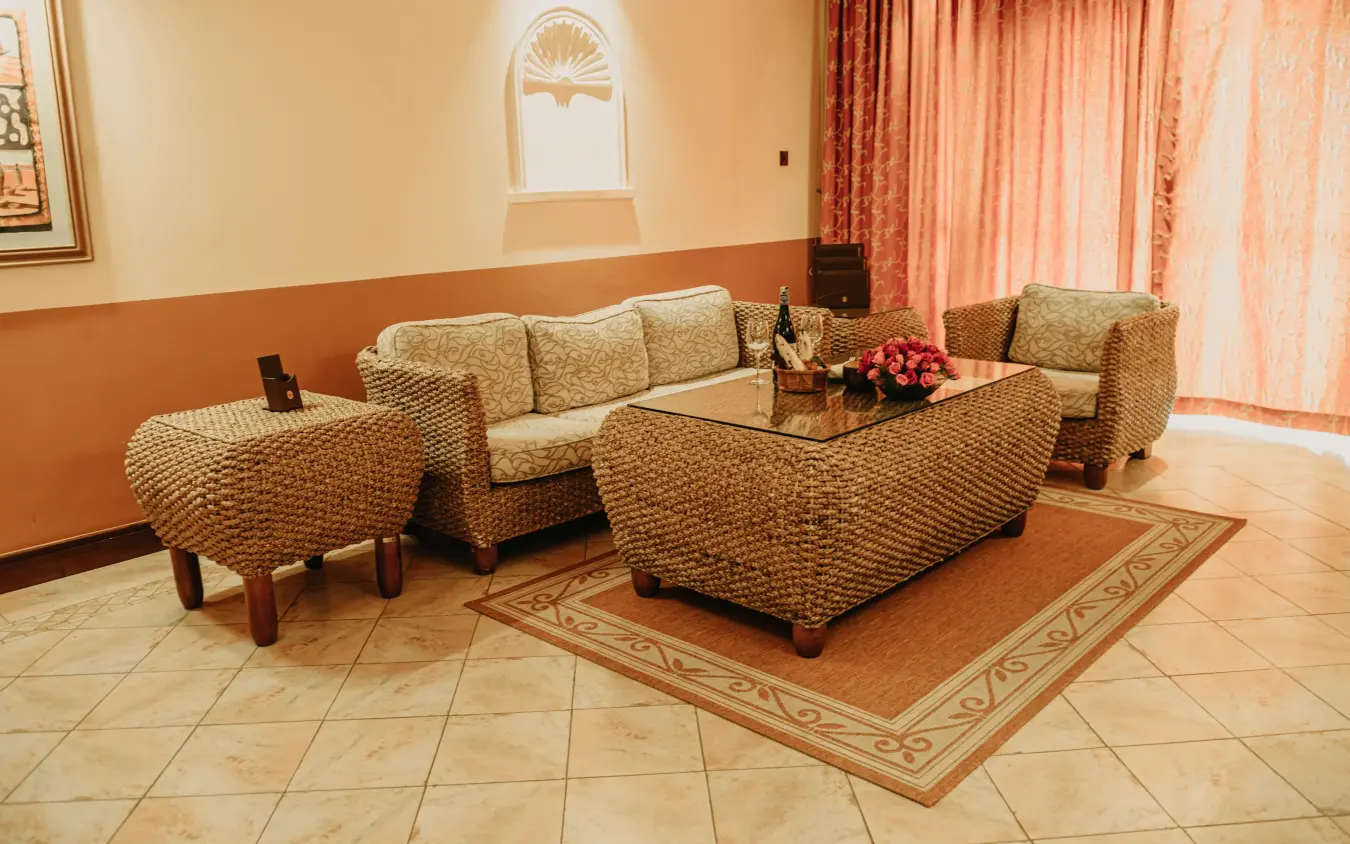 Woven furniture seating area with orange walls and arched window, Lake Victoria Serena Golf Resort & Spa, Entebbe and Kampala, Uganda