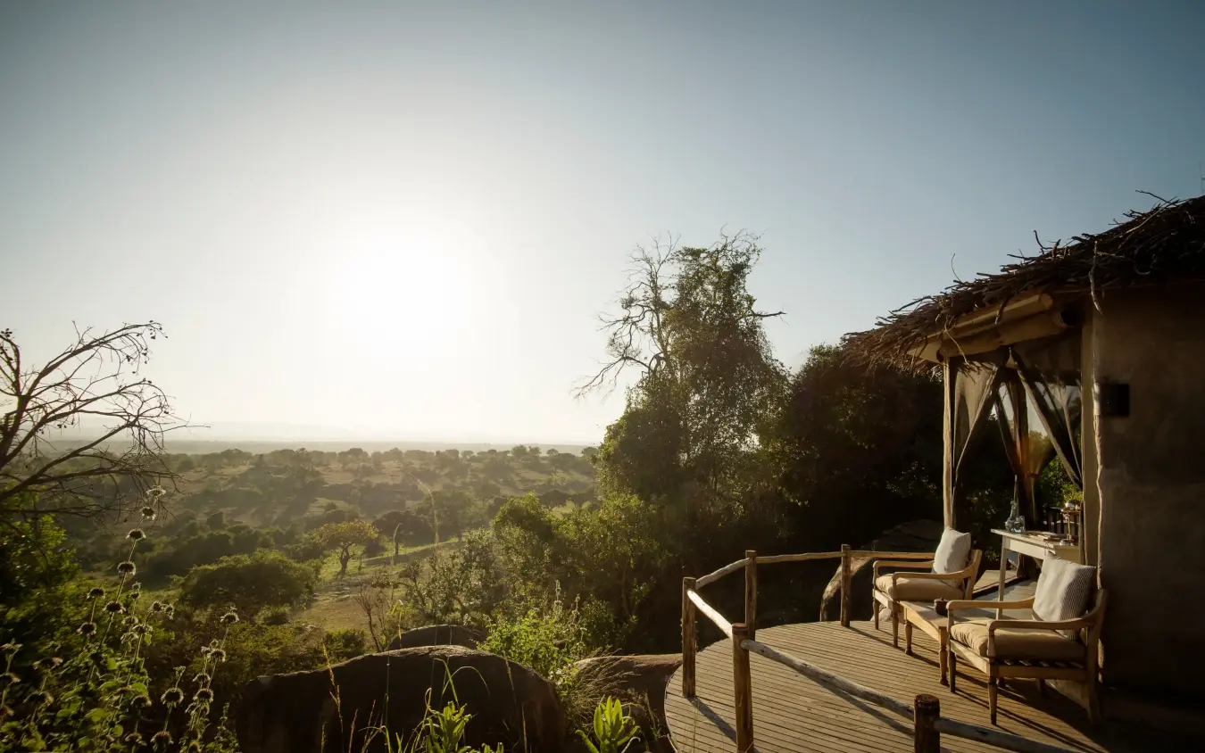 Wooden deck overlooking vast savanna landscape at sunset, Lamai Serengeti, Serengeti National Park, Tanzania