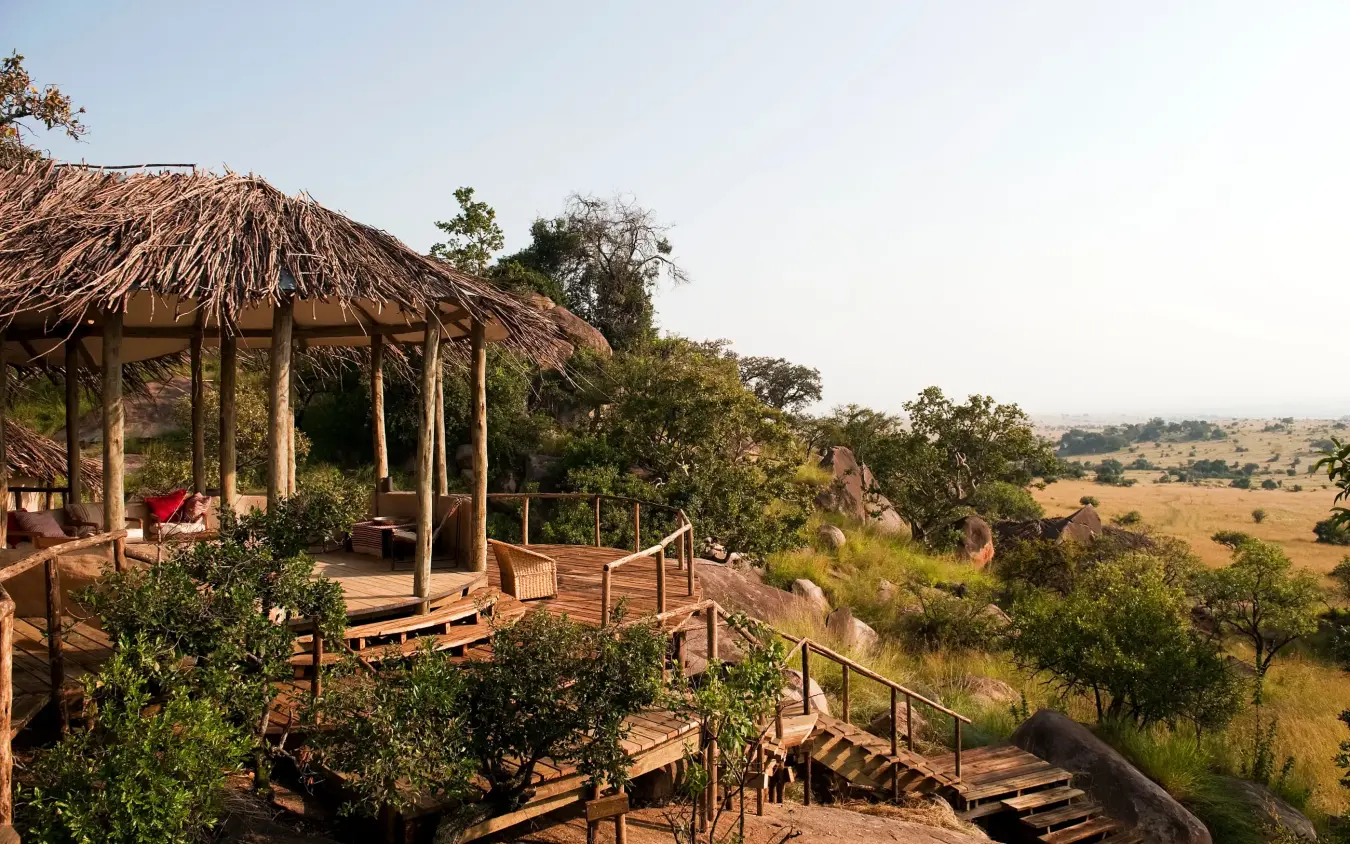 Thatched safari lodge deck overlooking vast savanna landscape, Lamai Serengeti, Serengeti National Park, Tanzania