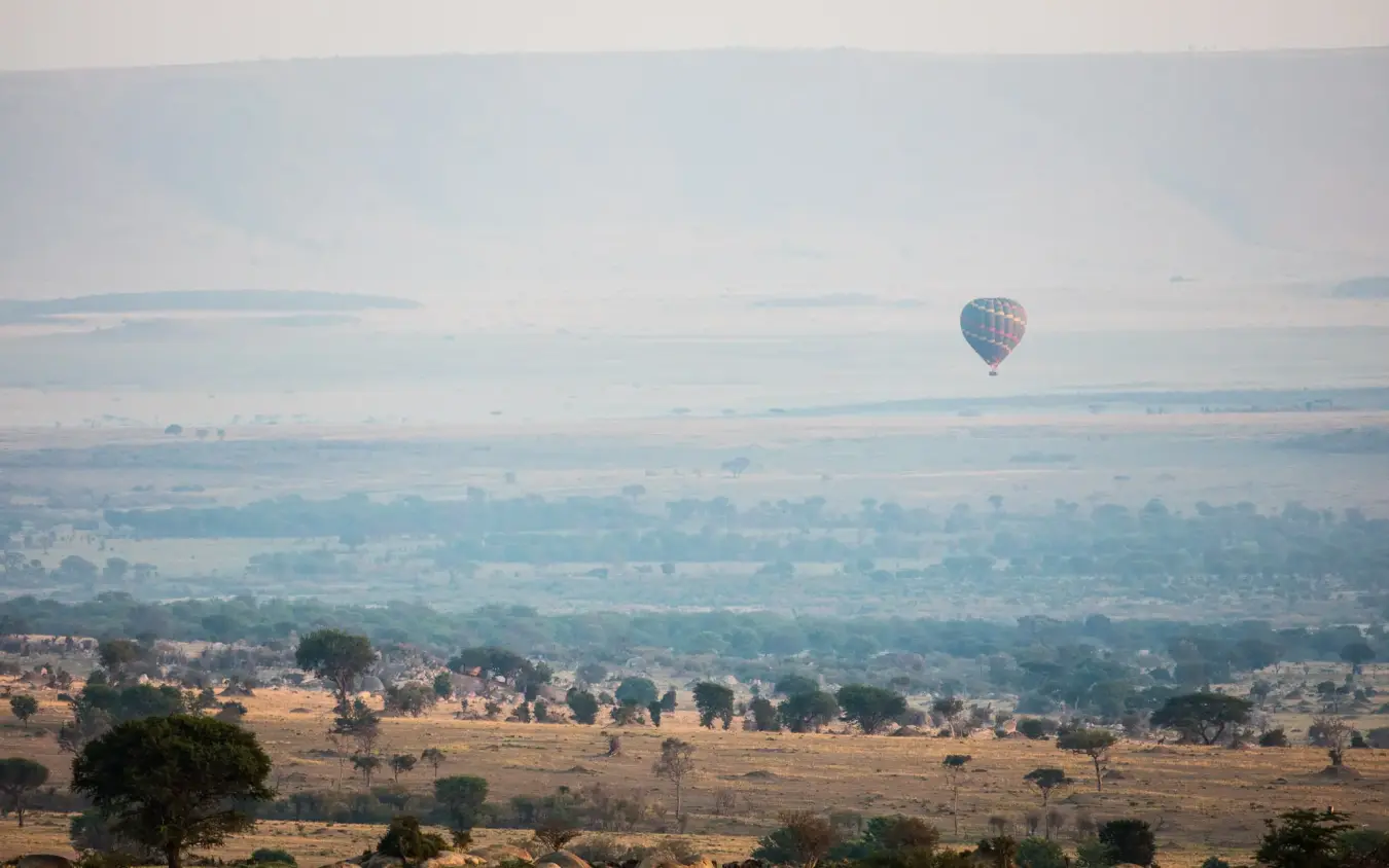Hot air balloon floating over savanna landscape at dawn, Nyasi Tented Camp, Serengeti National Park, Tanzania