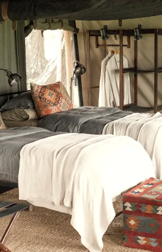 Family tent interior with two beds and decorative furnishings, Nyasi Tented Camp, Serengeti National Park, Tanzania