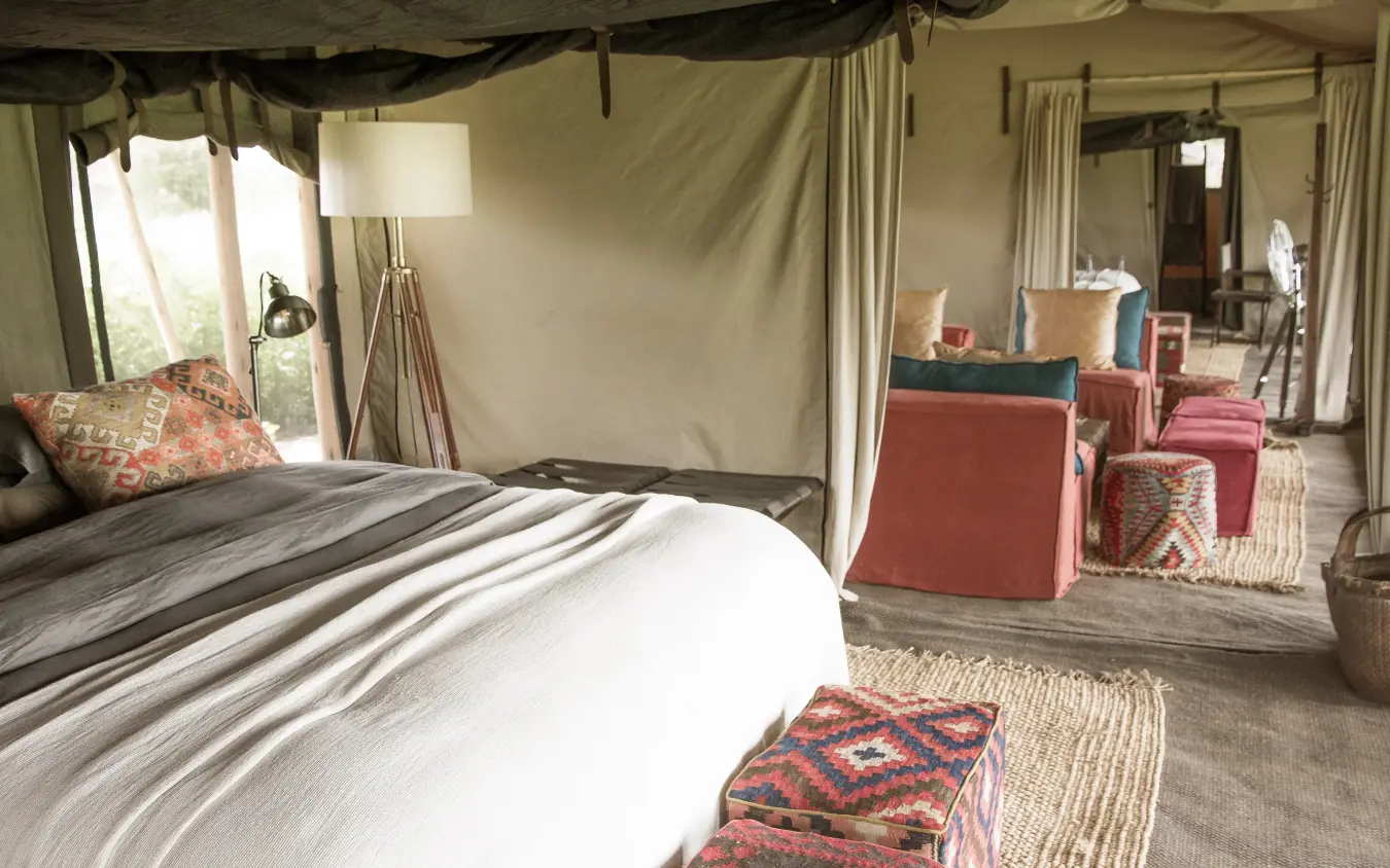 Spacious family tent bedroom with canopy bed and seating area, Nyasi Tented Camp, Serengeti National Park, Tanzania