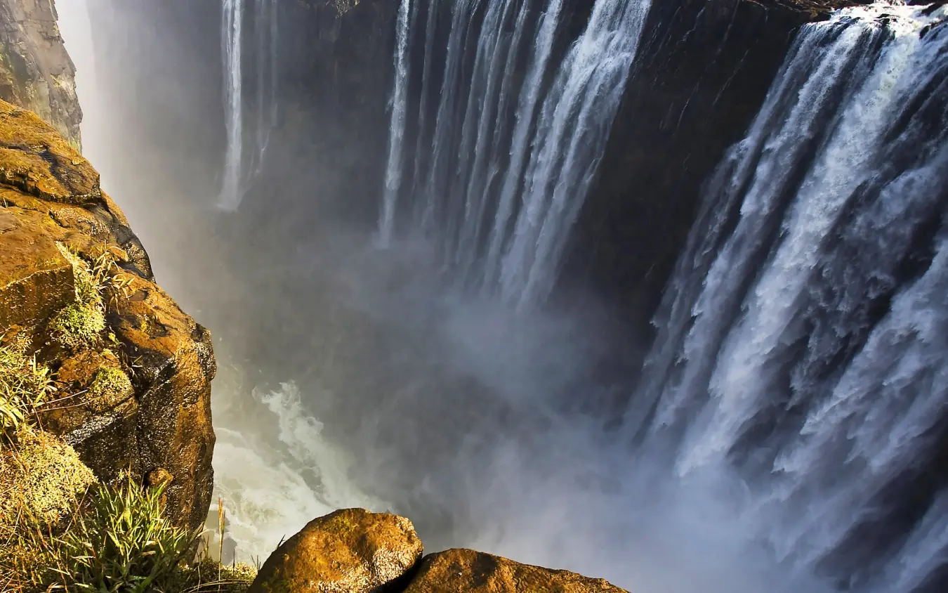 Powerful waterfall cascading over rocky cliffs with mist