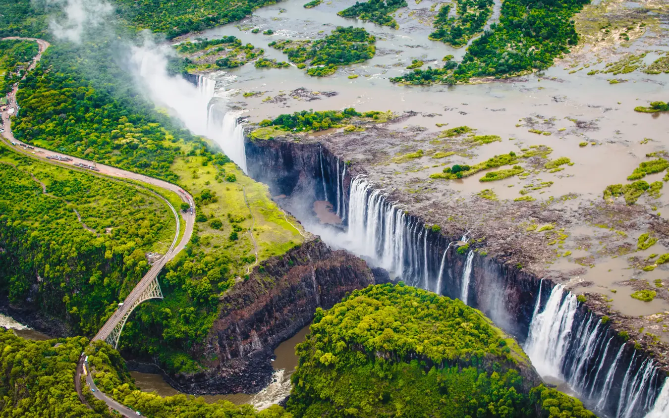 Aerial view of massive waterfall cascading into river valley
