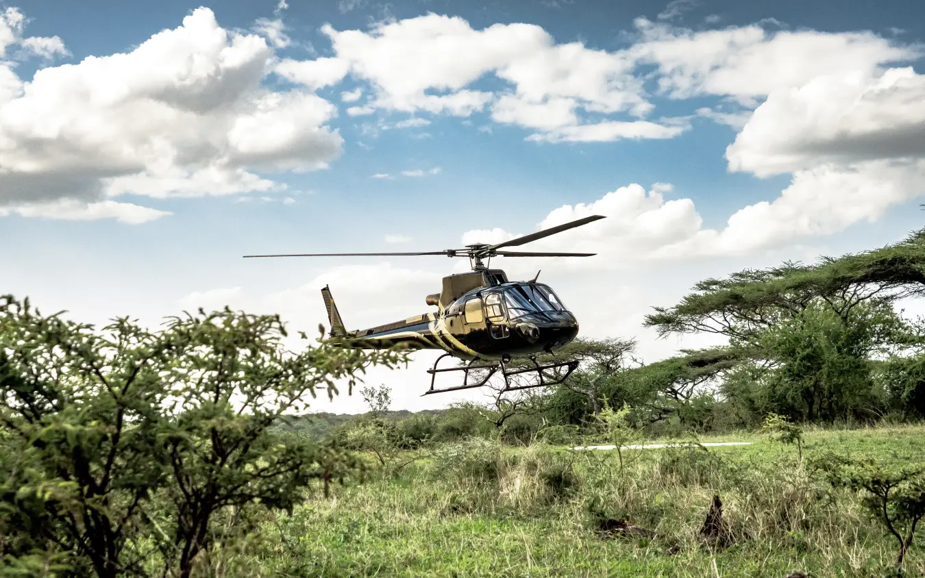 Helicopter landing in African savanna during safari expedition, Legendary Lodge, Arusha, Tanzania