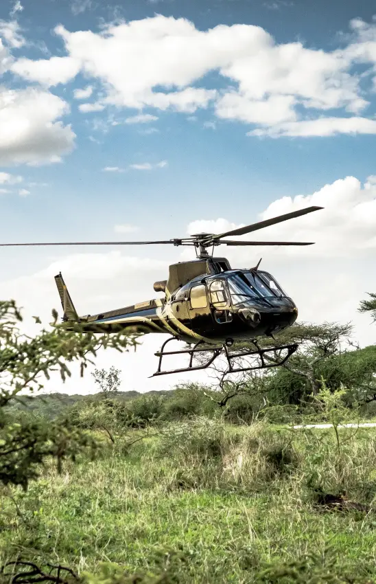 Helicopter landing in African savanna during safari expedition, Legendary Lodge, Arusha, Tanzania