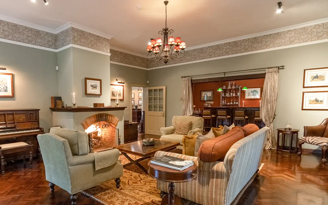 Elegant sitting room with fireplace, comfortable seating, and wood furnishings, Legendary Lodge, Arusha, Tanzania