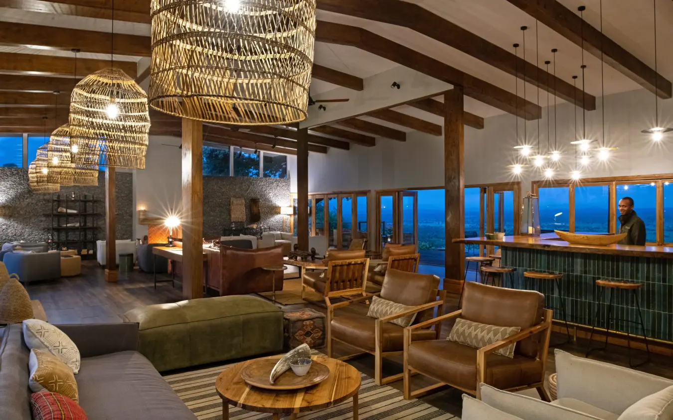 Modern lodge lounge with woven pendant lights and valley views at dusk, Mpingo Ridge Lodge, Tarangire National Park, Tanzania