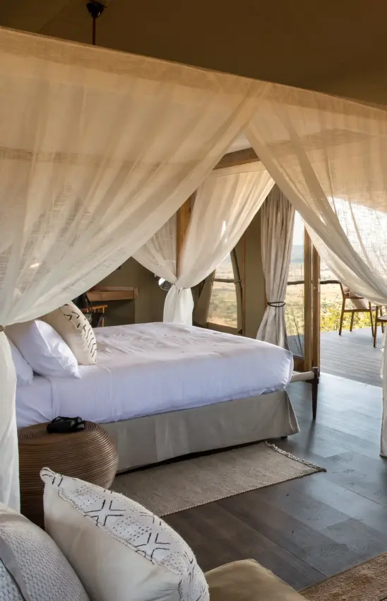 Four-poster canopy bed with sheer curtains overlooking savanna landscape, Mpingo Ridge Lodge, Tarangire National Park, Tanzania