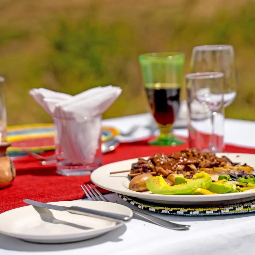 Plated meal with vegetables and meat at outdoor table, Lemala Ngorongoro, Ngorongoro Crater, Tanzania
