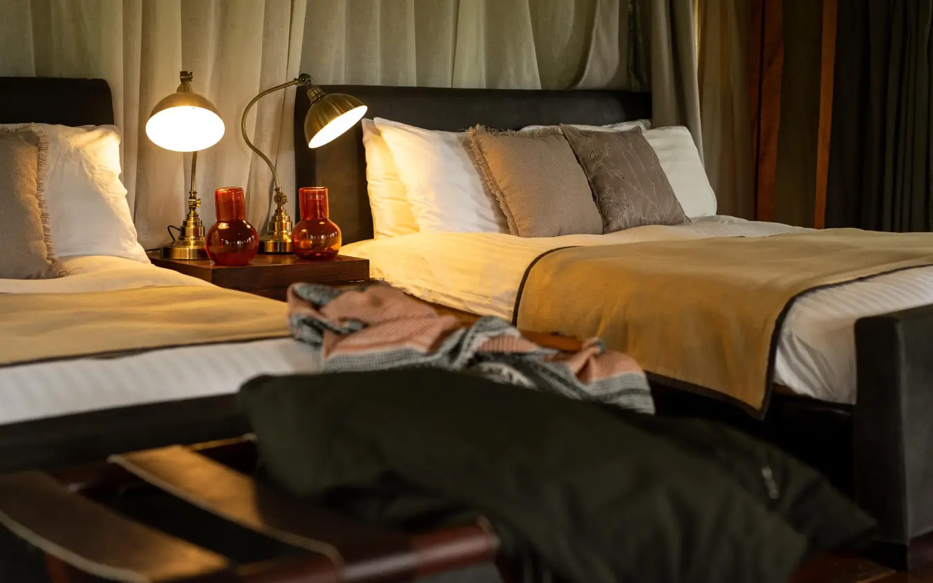 Luxury bedroom with dual beds and warm ambient lighting, Lemala Ngorongoro, Ngorongoro Crater, Tanzania