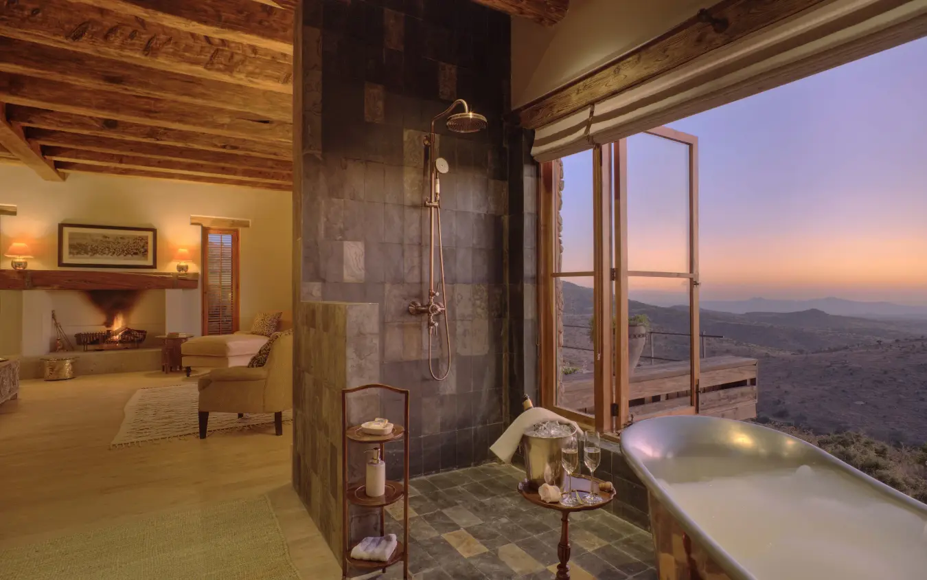Luxury bathroom with freestanding tub overlooking vast landscape at sunset, Lengishu House, Laikipia Highlands, Kenya