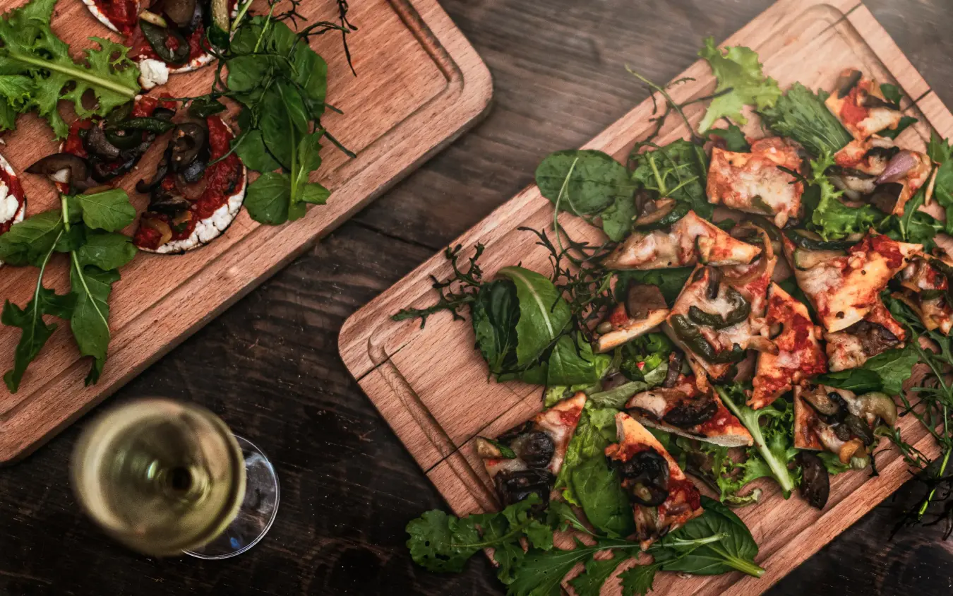 Plated appetizers on wooden boards with fresh herbs and wine, Lengishu House, Laikipia Highlands, Kenya