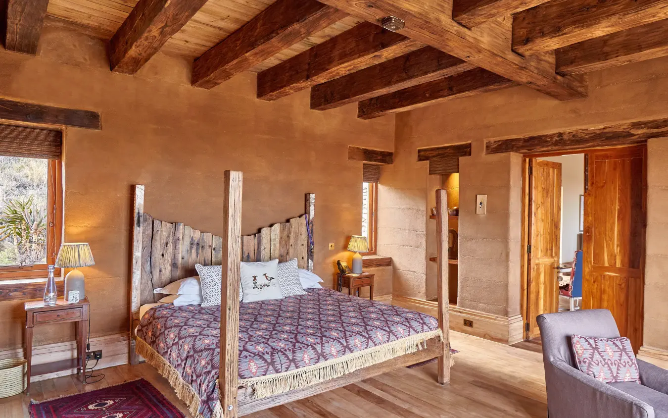 Spacious bedroom with four-poster bed and exposed wooden beams, Lengishu House, Laikipia Highlands, Kenya