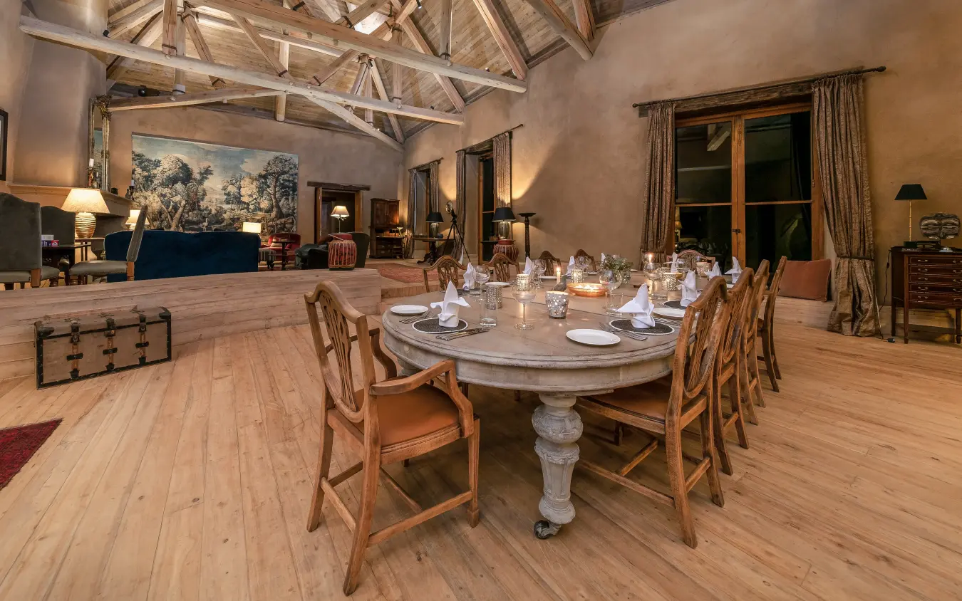 Large dining room with oval table and exposed beam ceiling, Lengishu House, Laikipia Highlands, Kenya