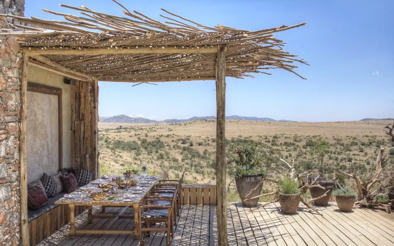 Wooden deck dining area overlooking arid savanna landscape, Lengishu House, Laikipia Highlands, Kenya
