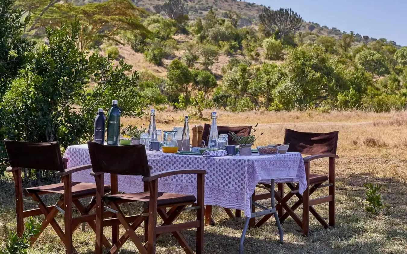 Outdoor dining setup with hillside views and natural landscape, Lengishu House, Laikipia Highlands, Kenya