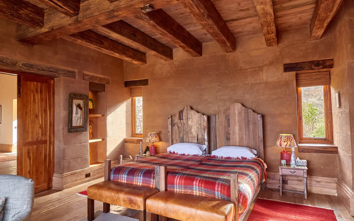 Bedroom with exposed wooden beams and twin beds, Lengishu House, Laikipia Highlands, Kenya