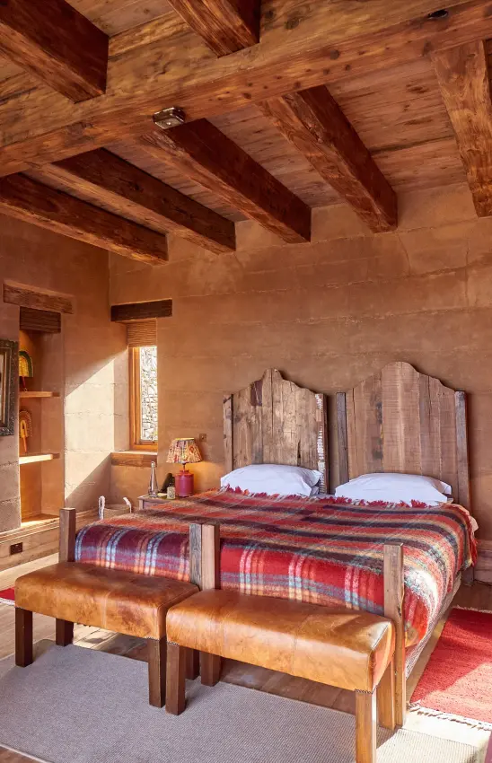 Bedroom with exposed wooden beams and twin beds, Lengishu House, Laikipia Highlands, Kenya