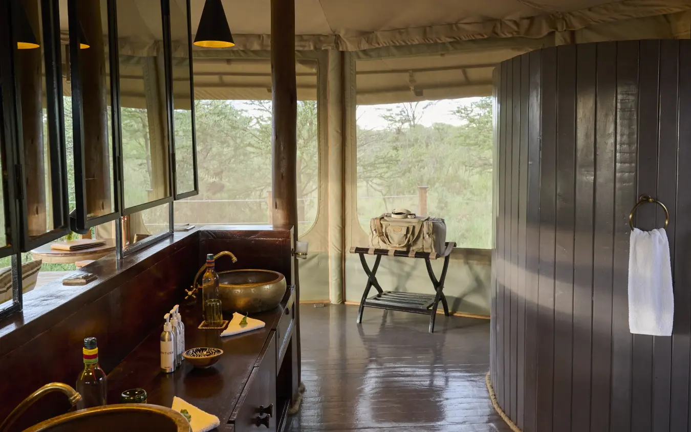 Luxury safari bathroom with basin and mirror overlooking bushveld landscape, Leopard Hill, Maasai Mara, Kenya