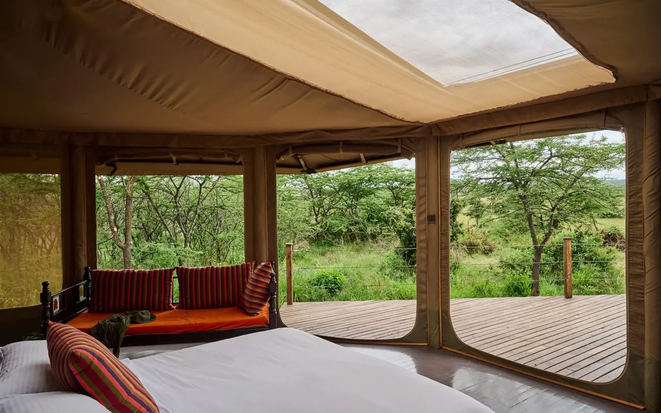 Luxury safari tent bedroom with open-air deck overlooking woodland savanna, Leopard Hill, Maasai Mara, Kenya